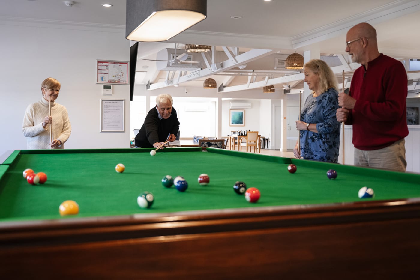 group of people playing pool in clubhouse